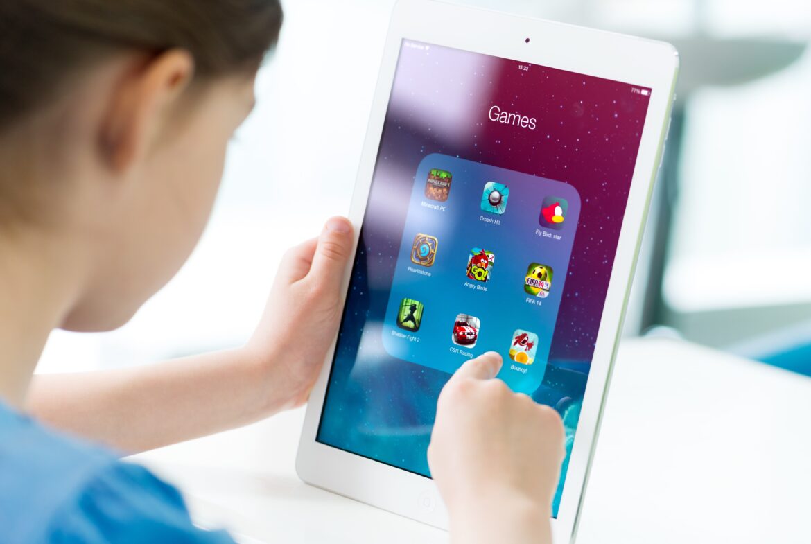 kid playing games on ipad